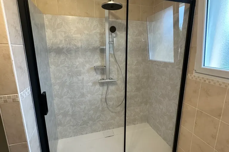 Rénovation salle de bain par Éclat d'Idée : douche avec paroi vitrée noire après les travaux à Longeville-sur-Mer
